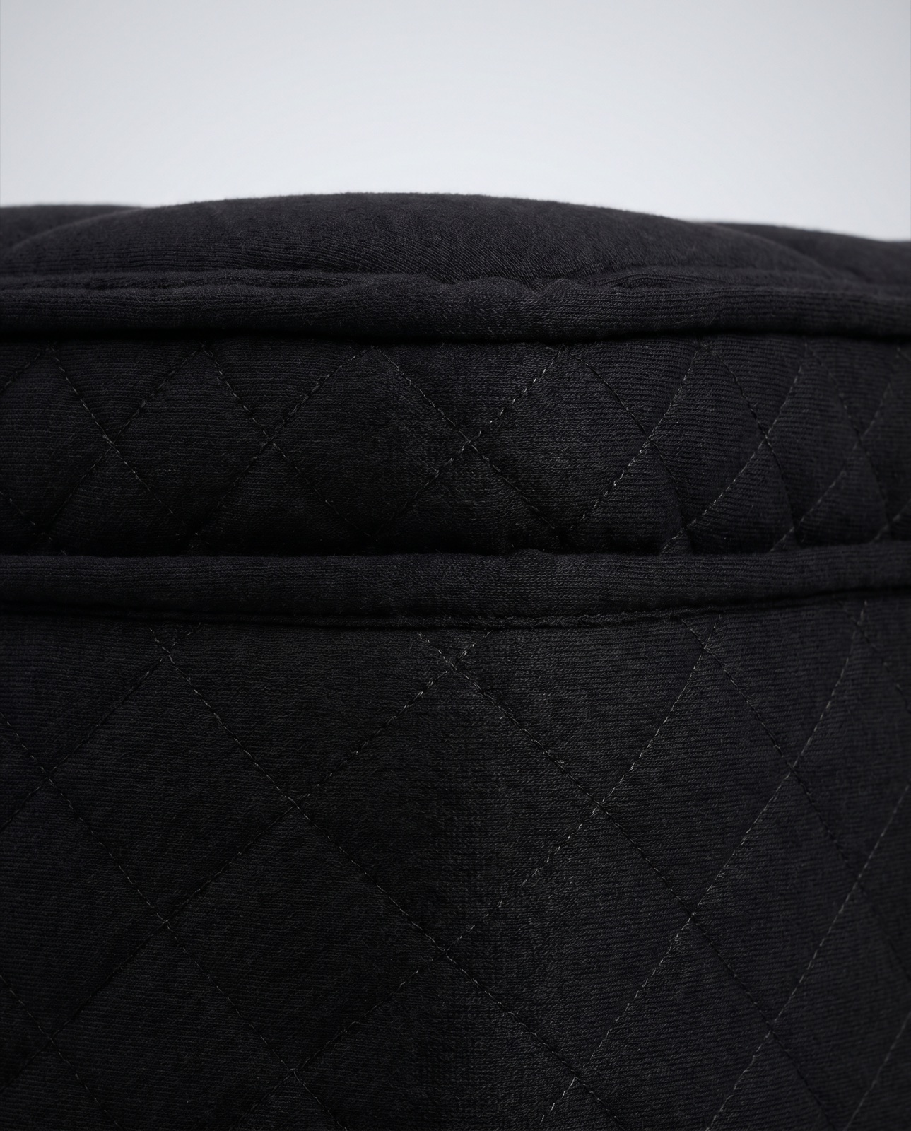 Close-up of premium black quilted knit mattress fabric with fine diamond stitching
