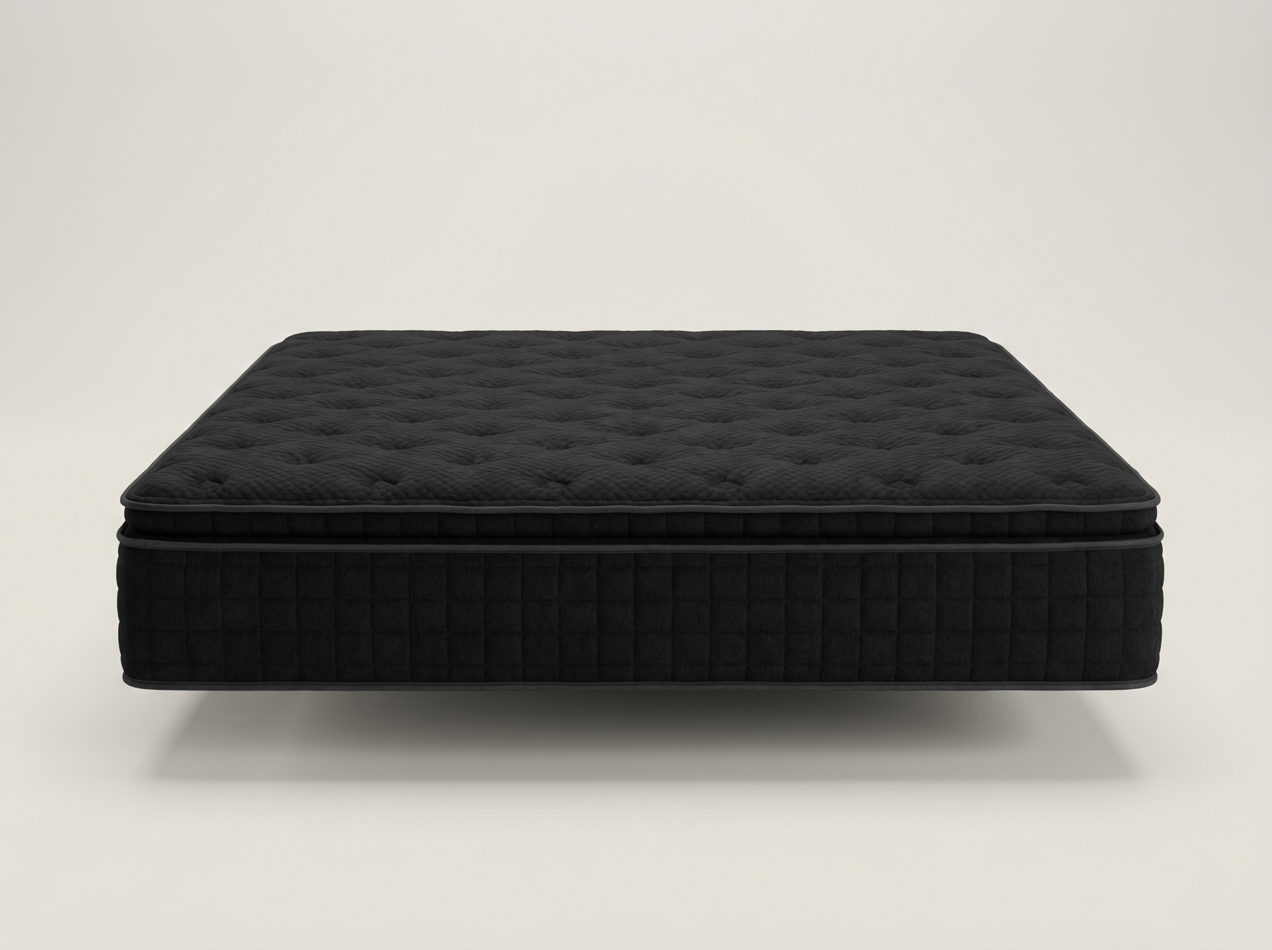 All-black quilted king mattress on a bright light studio backdrop, clearly showing the black fabric